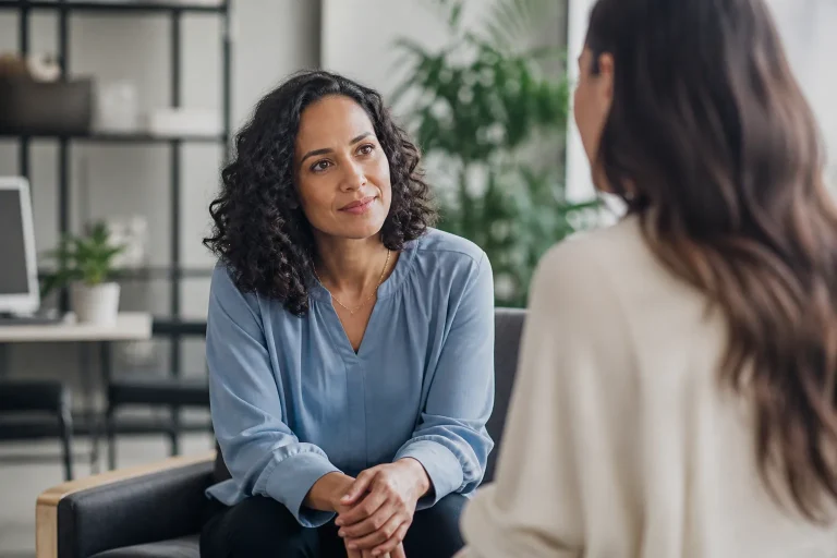 A diverse group of professionals engaging in a thoughtful discussion in a modern office setting, bathed in warm natural light.